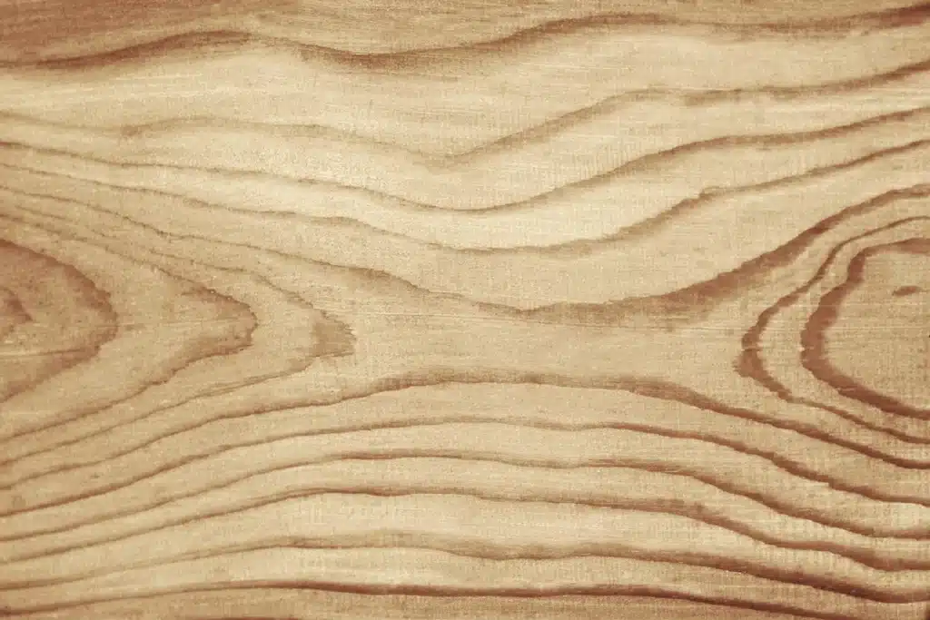 Texture de bois en arrière-plan, mettant en valeur un bardage composite élégant et moderne.