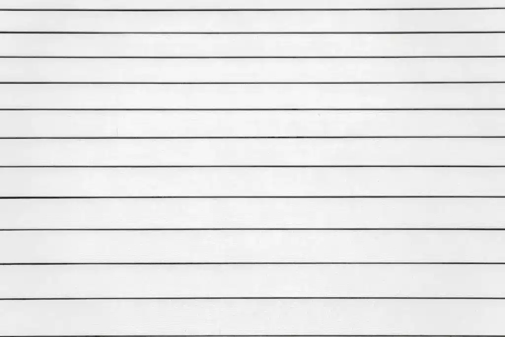 Gros plan sur des lattes de bardage PVC blanc emballées, prêtes à être installées pour habiller une façade.