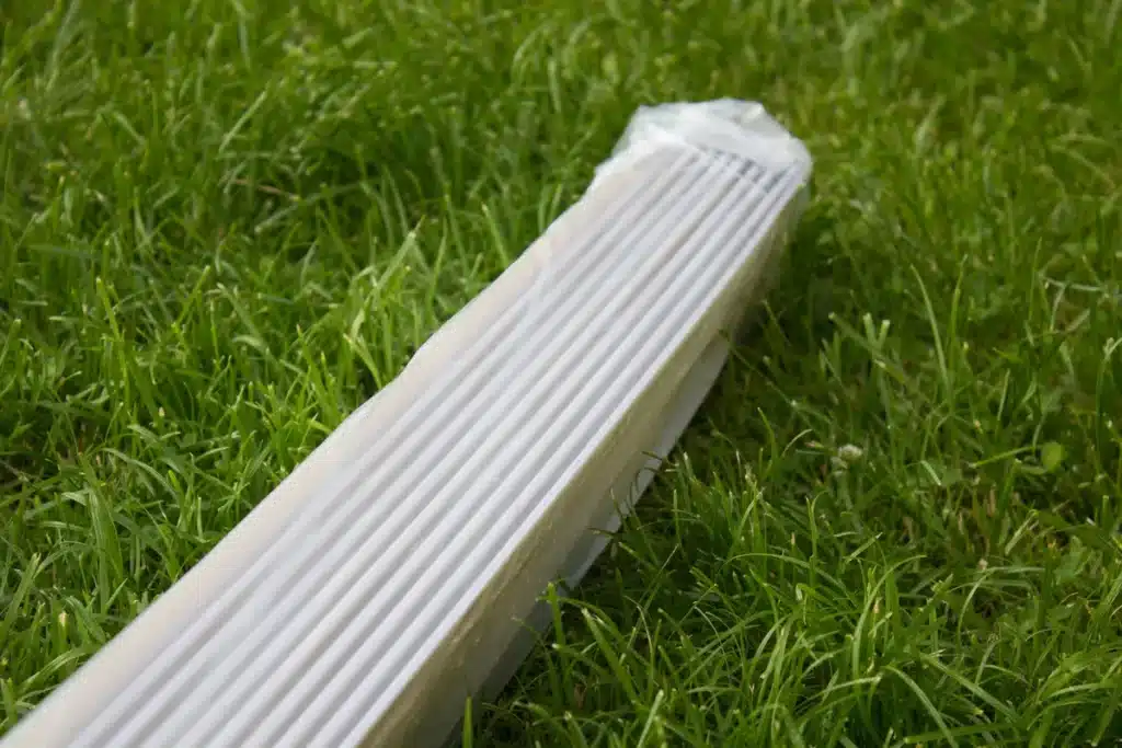 Revêtement de façade en PVC blanc imitant l’aspect du bois avec des lames horizontales, idéal pour un rendu naturel et sans entretien.